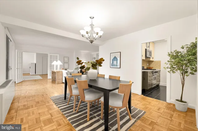 a dining room with chandelier and wooden floor