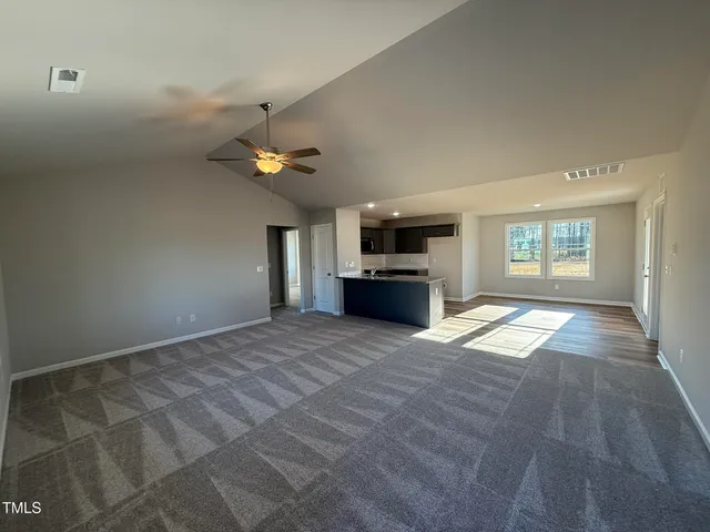 a view of empty room with wooden floor and window