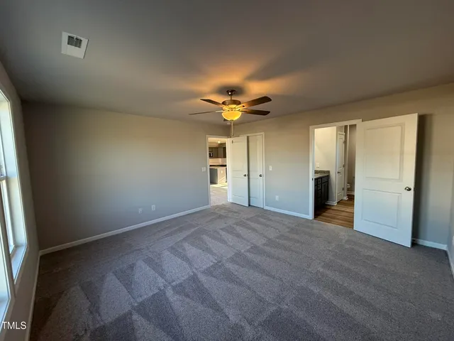 an empty room with a ceiling fan and a window