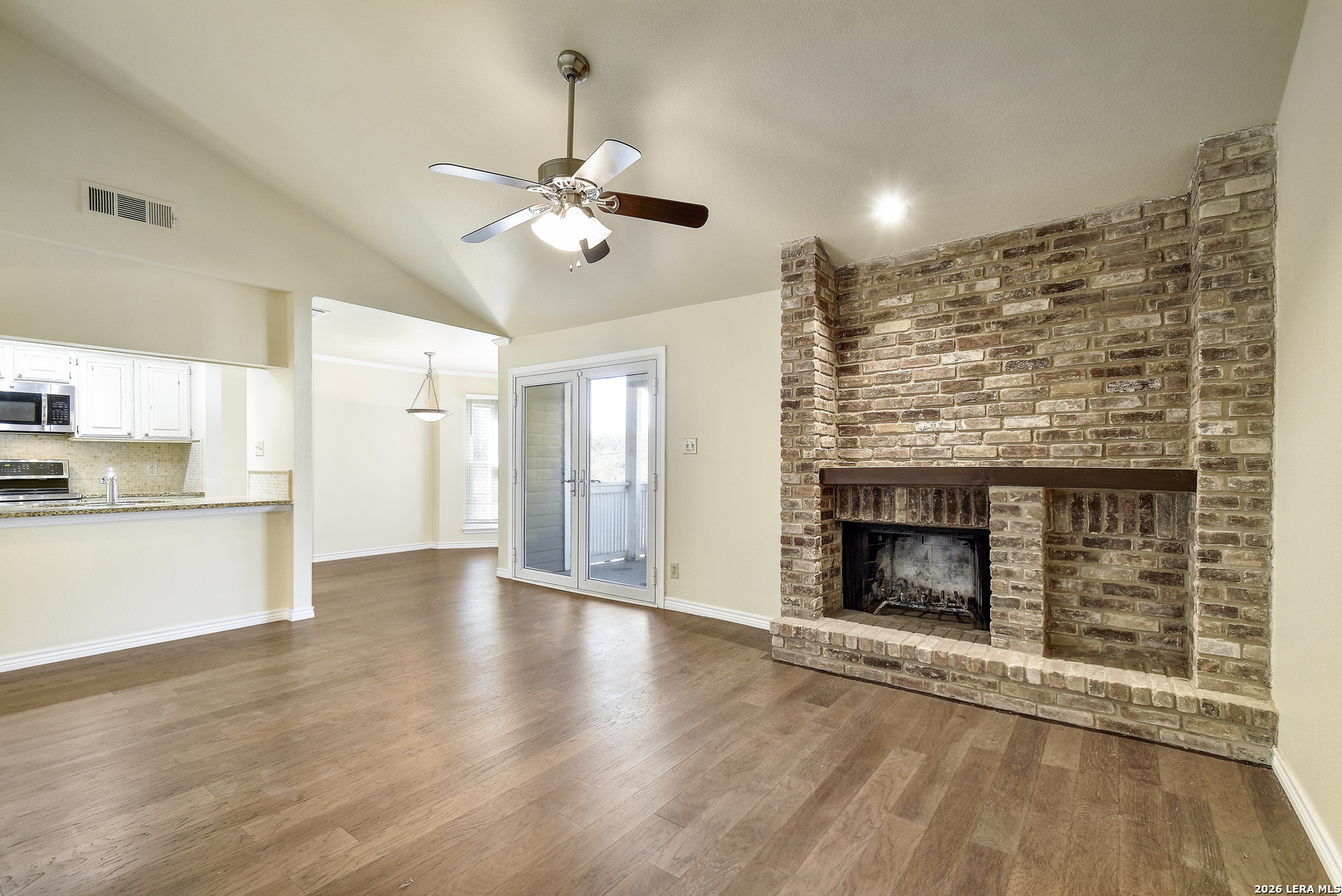 13130 Blanco Road, Unit 1706 San Antonio, TX 78216 - Photo 2 of 23 a view of a kitchen with a stove wooden floor a ceiling fan and a kitchen