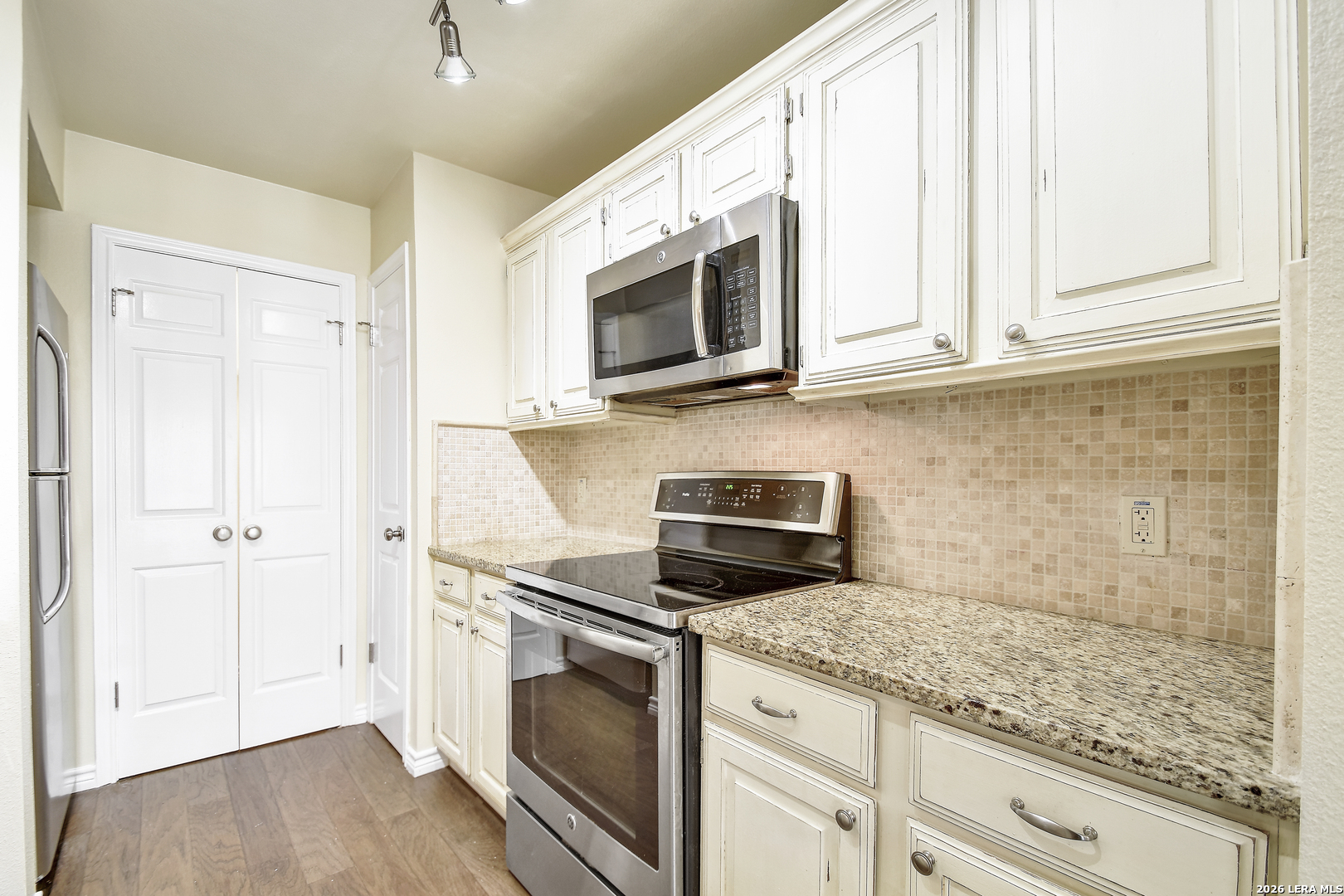 13130 Blanco Road, Unit 1706 San Antonio, TX 78216 - Photo 9 of 23 a kitchen with granite countertop cabinets stainless steel appliances and wooden floor