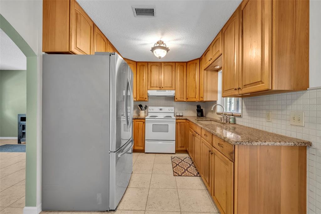 430 Cypress Isles Road Osteen, FL 32764 - Photo 12 of 55 a kitchen with stainless steel appliances granite countertop a stove a sink and a refrigerator