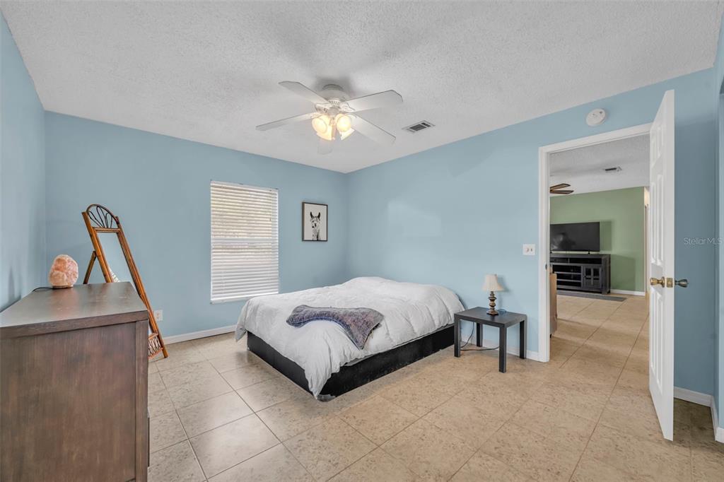 430 Cypress Isles Road Osteen, FL 32764 - Photo 17 of 55 a bedroom with a bed and a chandelier