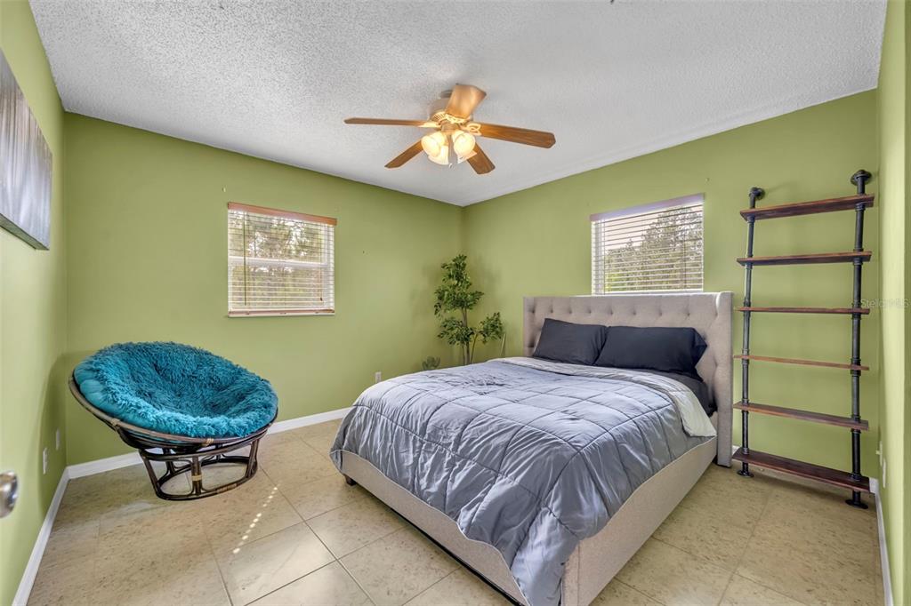 430 Cypress Isles Road Osteen, FL 32764 - Photo 22 of 55 a bedroom with a bed and a chandelier