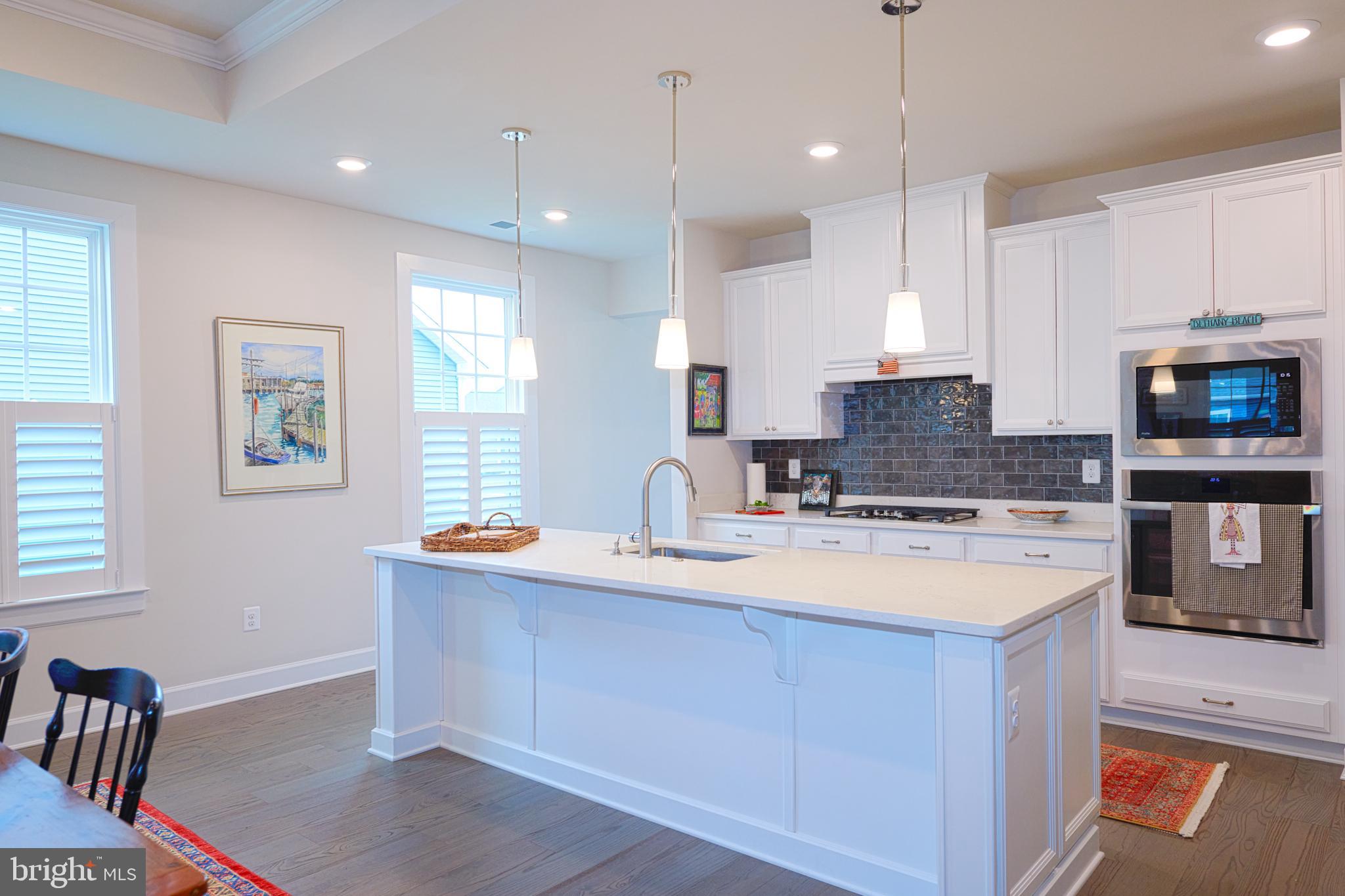 33173 Ponte Vecchio Plaza Ocean View, DE 19970 - Photo 4 of 19 a large kitchen with stainless steel appliances granite countertop a sink a stove a microwave a center island and cabinets