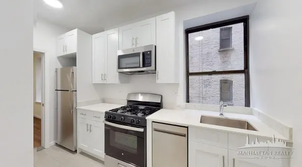 a kitchen with granite countertop a sink stove and refrigerator