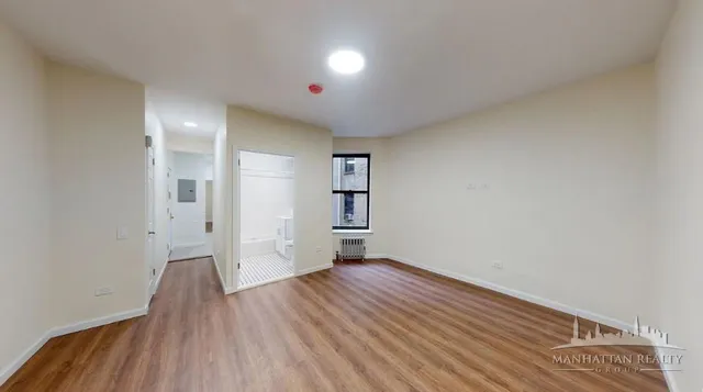 a view of a hallway with wooden floor and closet