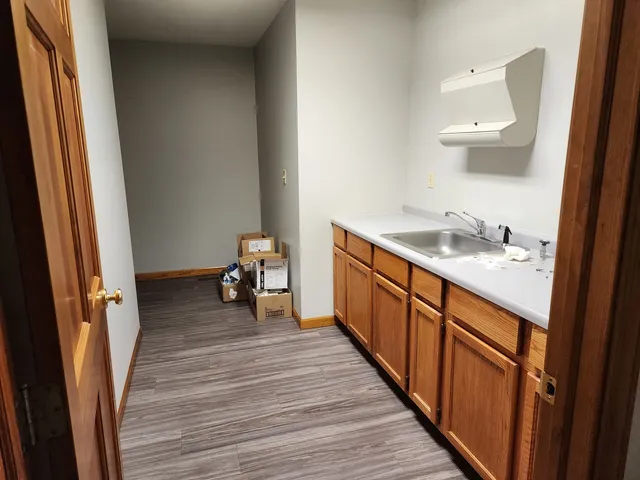 a hallway with a wooden floor and a sink