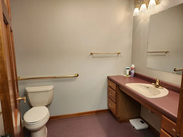 a bathroom with a granite countertop sink a toilet and a mirror