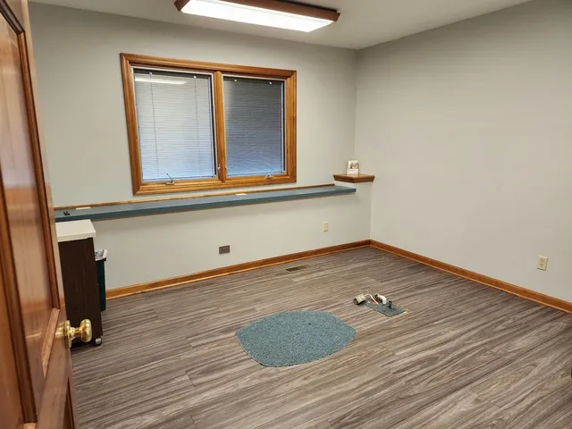 an empty room with wooden floor and cabinet