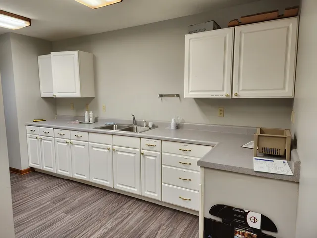a kitchen with granite countertop white cabinets and white appliances