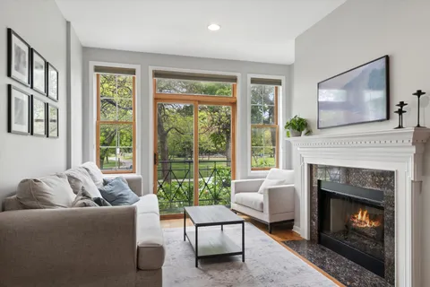 a living room with furniture a large window and a fireplace
