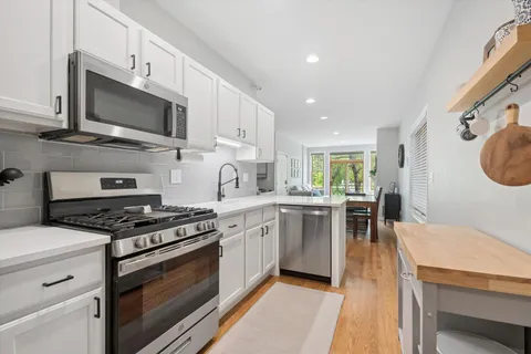 a kitchen with stainless steel appliances a stove a sink and a microwave