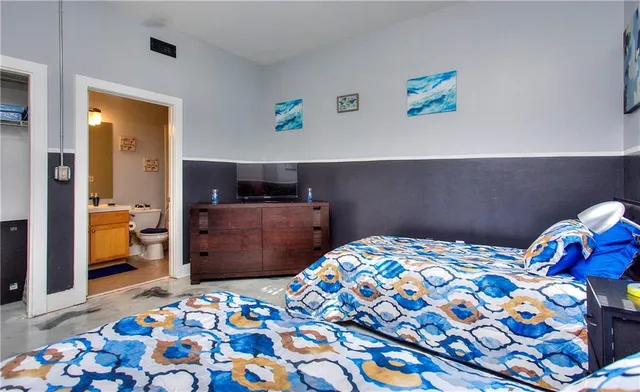 a bedroom with two beds and a chandelier