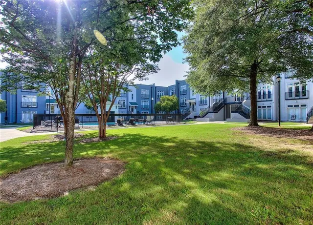 a view of a house with a big yard and large trees