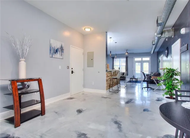 a living room with furniture kitchen view and a large window