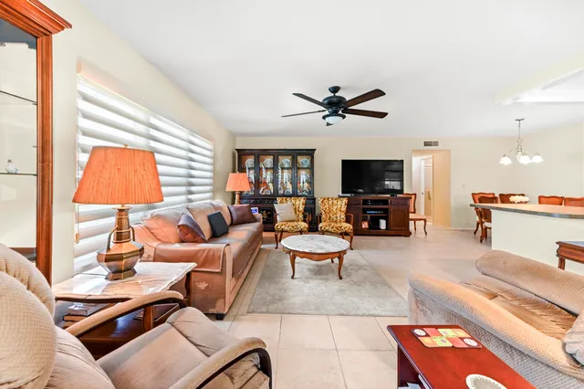 a living room with furniture flat screen tv and a large window