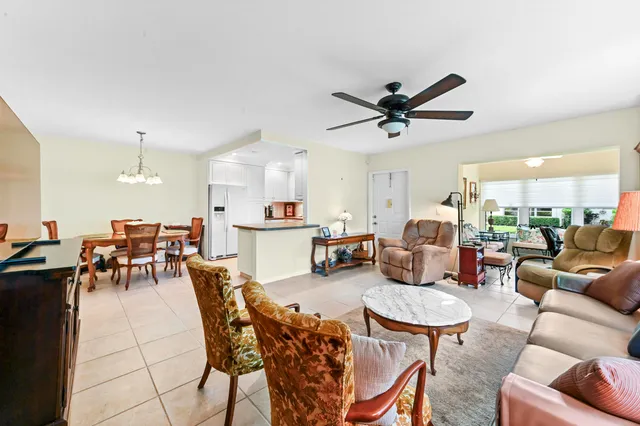 a living room with furniture a kitchen view and a dining table