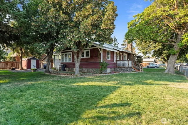 a view of a house with backyard and a tree