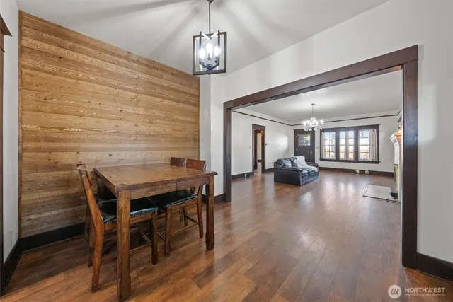 a view of a dining room and livingroom with furniture wooden floor a chandelier