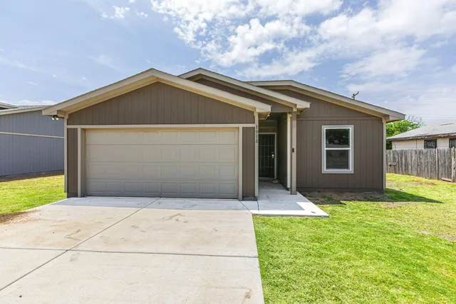 a front view of house with yard and garage