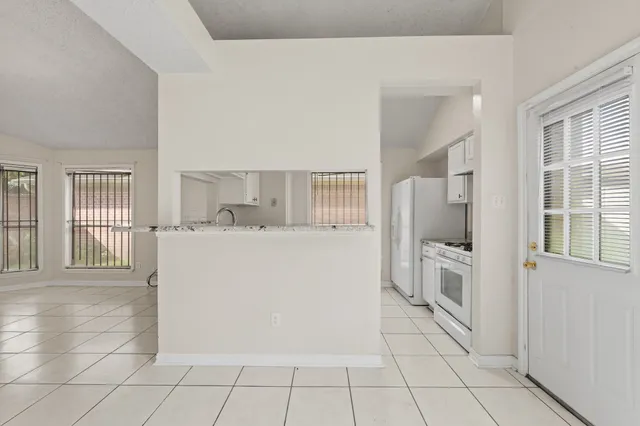 a view of kitchen with furniture and refrigerator