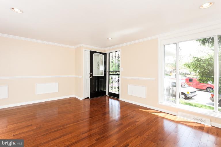 5540 Silverbell Road Baltimore, MD 21206 - Photo 2 of 30 a view of an empty room with wooden floor and a window