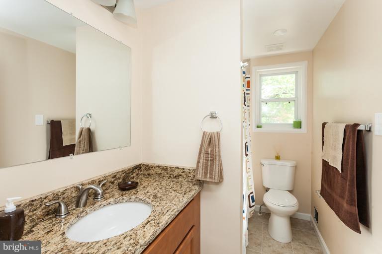 5540 Silverbell Road Baltimore, MD 21206 - Photo 15 of 30 a bathroom with a granite countertop sink toilet and shower