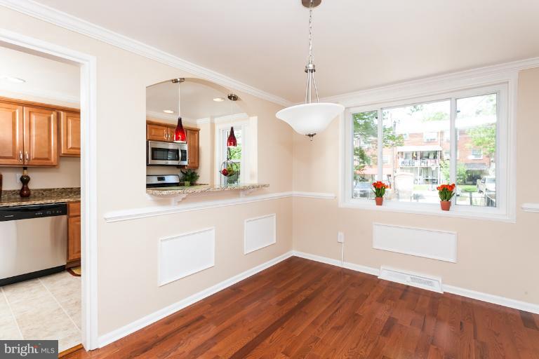 5540 Silverbell Road Baltimore, MD 21206 - Photo 19 of 30 a kitchen with stainless steel appliances white cabinets and wooden floors