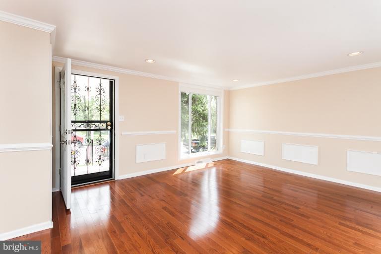 5540 Silverbell Road Baltimore, MD 21206 - Photo 22 of 30 an empty room with wooden floor and windows