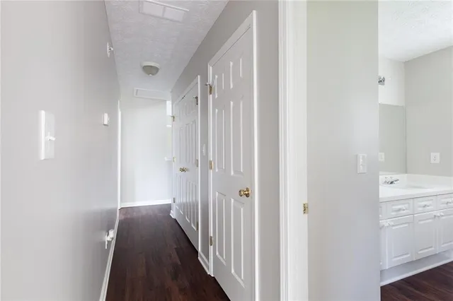 a view of a hallway with a closet and wooden floor