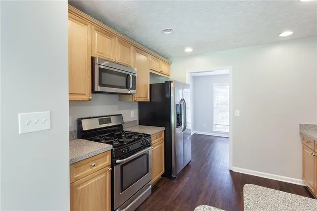 a kitchen with stainless steel appliances a stove a microwave and cabinets