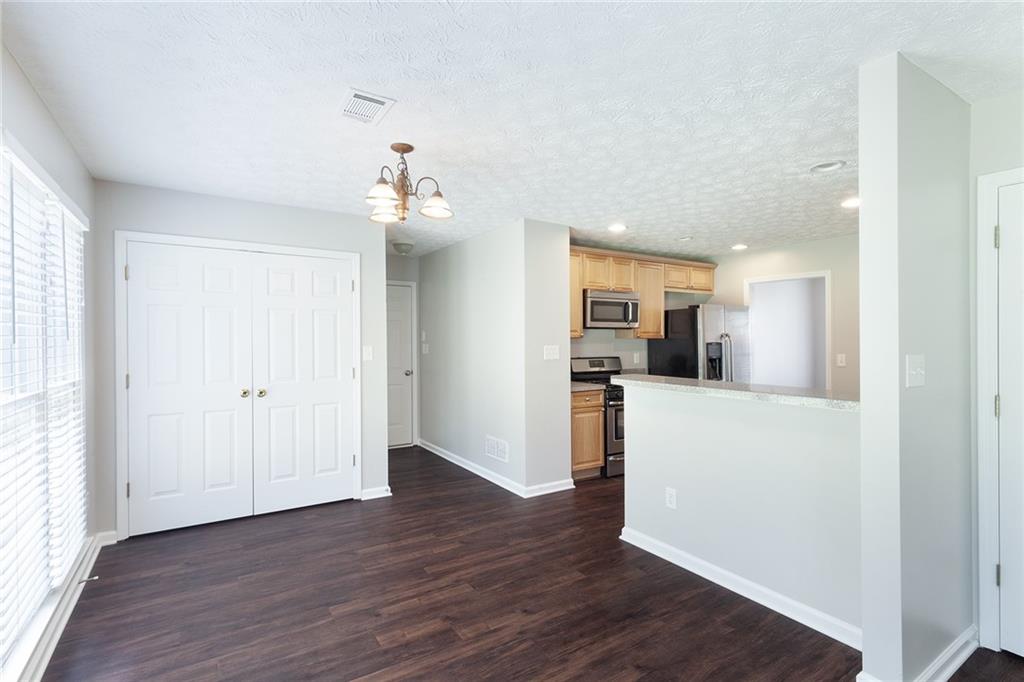 49 Parkside Drive Dallas, GA 30157 - Photo 10 of 31 a view of a kitchen and an empty room with wooden floor and windows