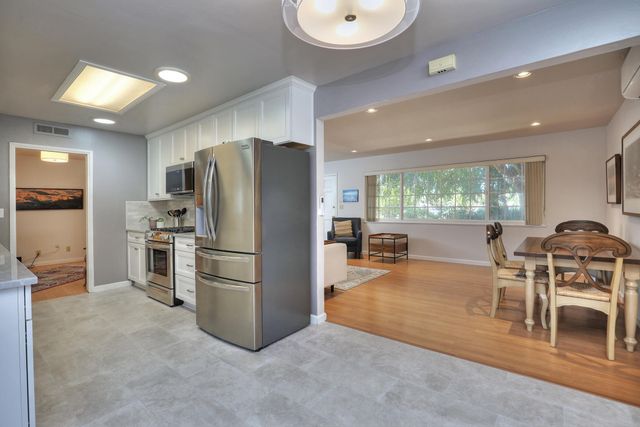 a kitchen with stainless steel appliances a stove a refrigerator and furniture