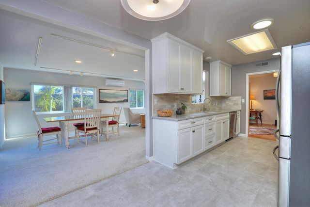 a kitchen with a white cabinets and chairs in it
