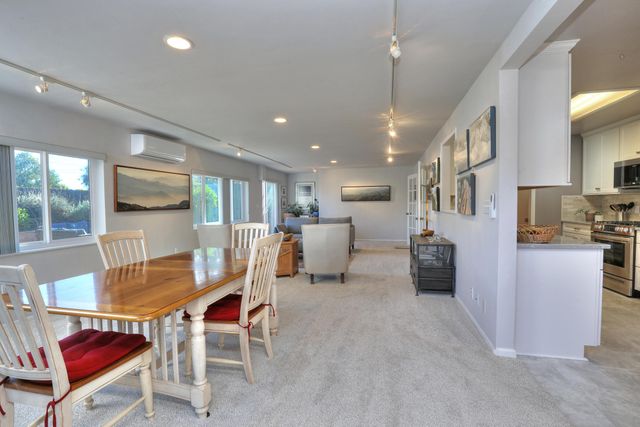 a dining room with furniture and a kitchen view