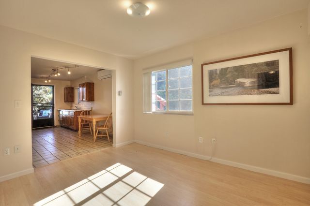 a living room with furniture a dining table and a painting on the wall