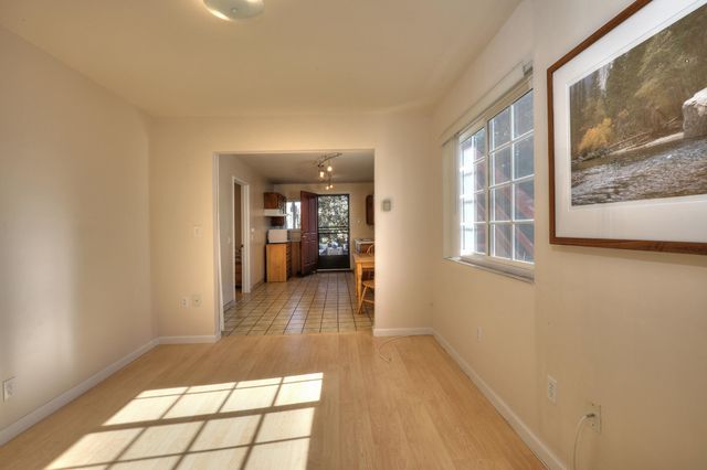 a view of a hallway with wooden floor and a living room