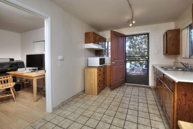 a kitchen with stainless steel appliances kitchen island granite countertop a refrigerator and a stove top oven