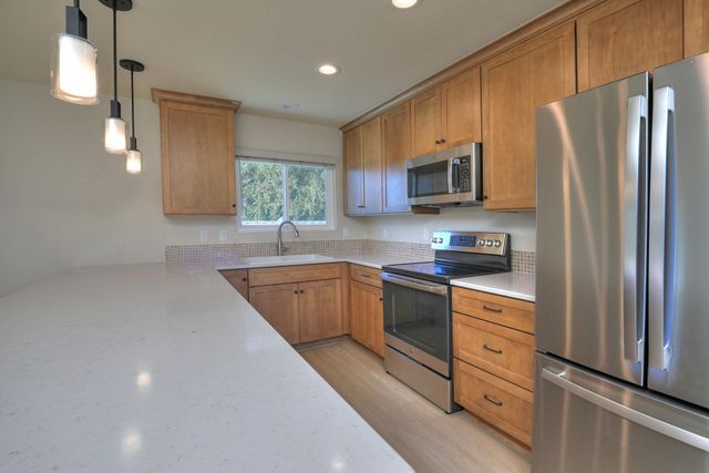 a kitchen with granite countertop a refrigerator stove and microwave