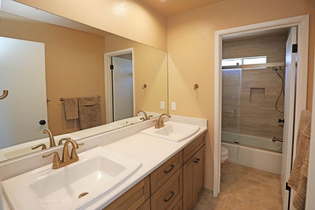 a bathroom with a sink tub vanity and a mirror