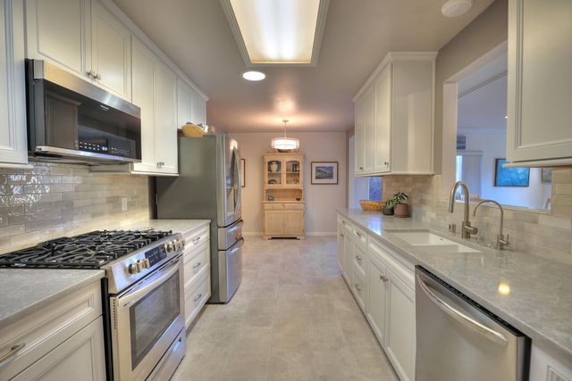 a kitchen with stainless steel appliances granite countertop a sink stove and microwave