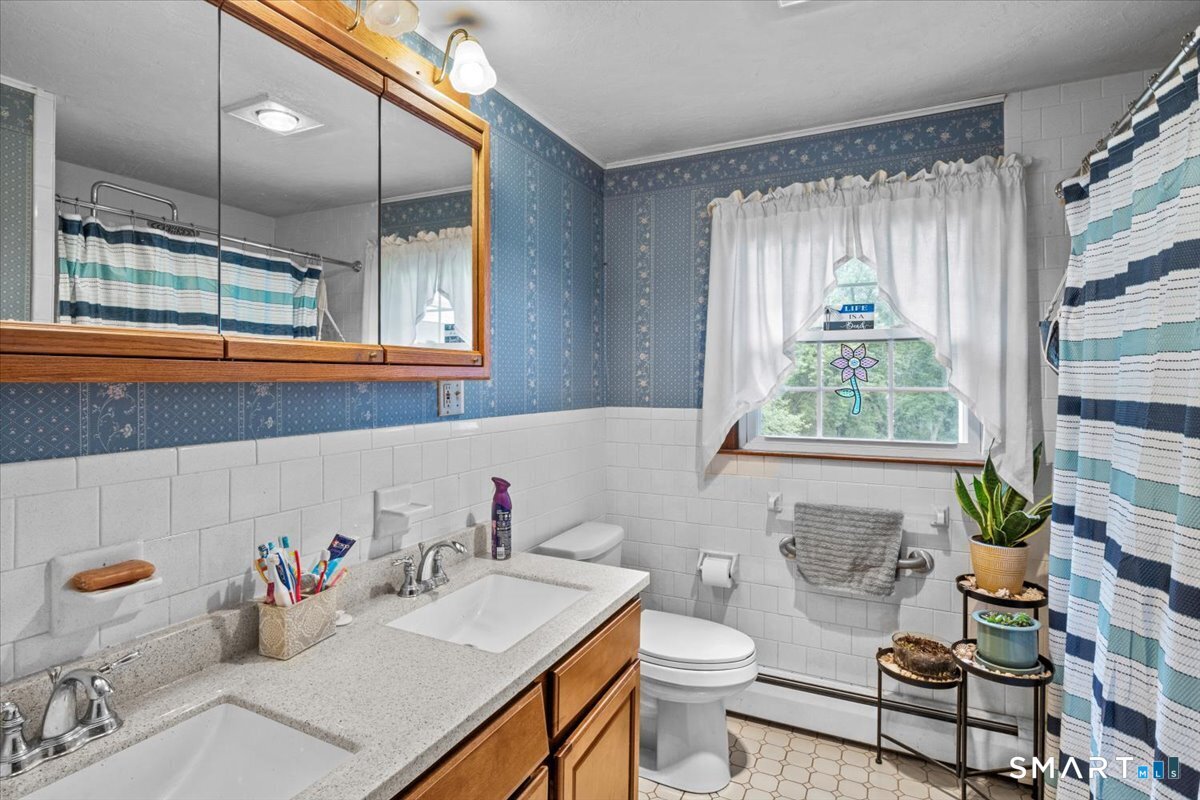 88 Pompeo Road Thompson, CT 06255 - Photo 19 of 40 a bathroom with a sink mirror toilet and next to a window