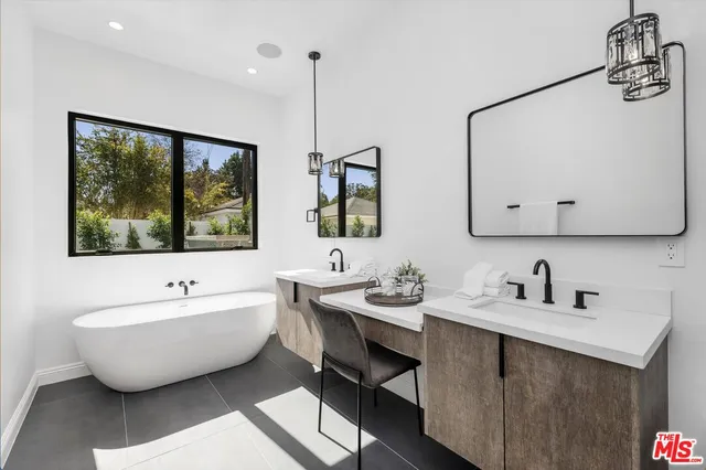 a bathroom with a double vanity sink mirror and shower