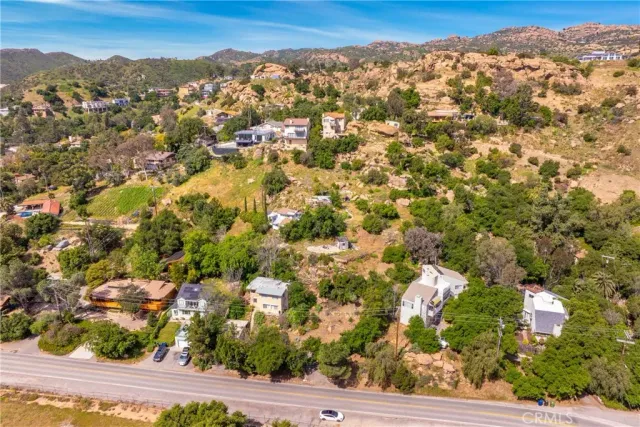 an aerial view of residential houses with outdoor space and trees