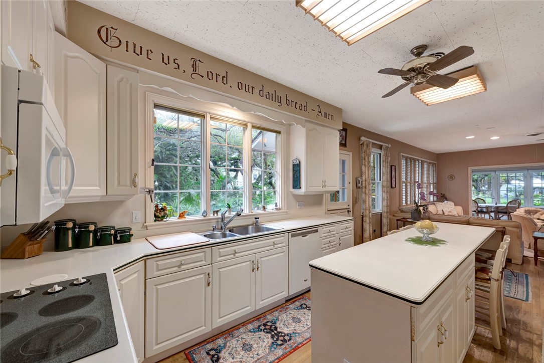 3765 Flamingo Drive Vero Beach, FL 32963 - Photo 10 of 28 a kitchen with a stove a sink dishwasher a kitchen island with wooden cabinets and floor