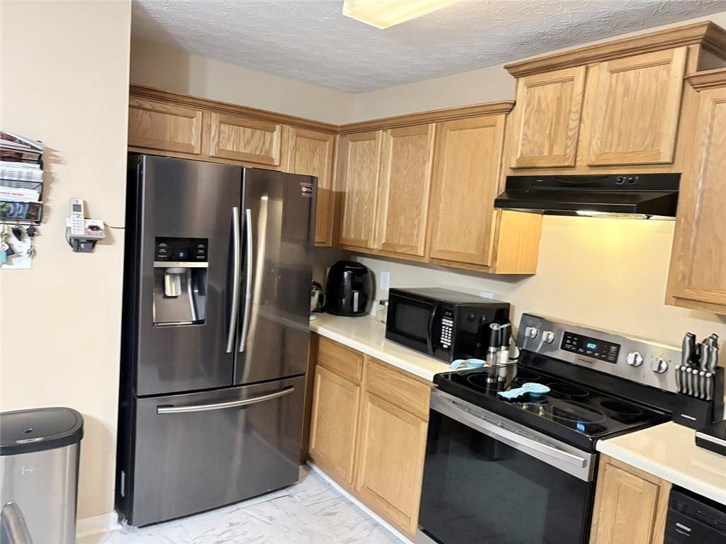 35 Pembroke Place Covington, GA 30016 - Photo 13 of 32 a kitchen with a refrigerator stove and cabinets