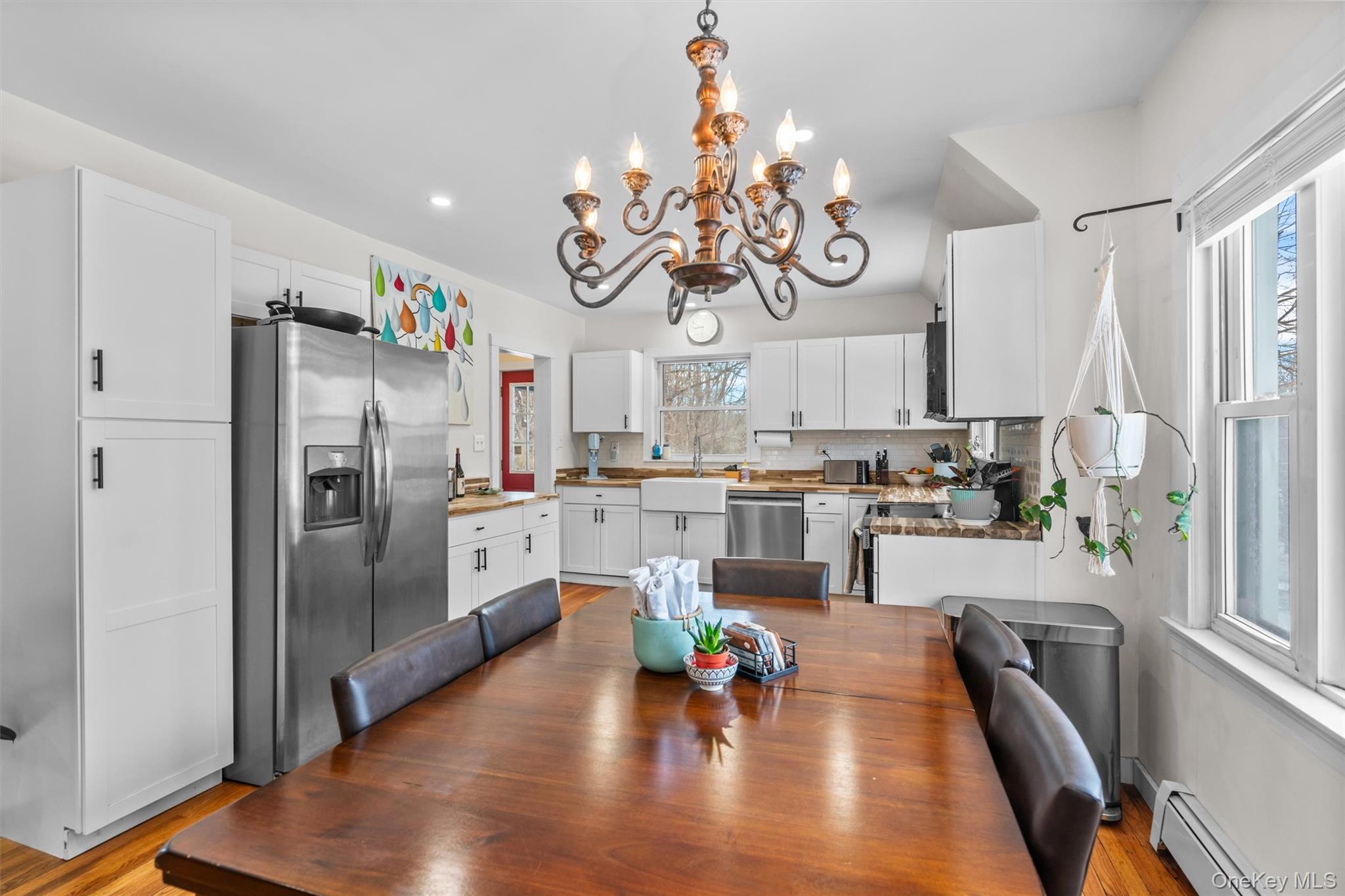 38 Post Hill Road Mountain Dale, NY 12763 - Photo 15 of 27 Dining space featuring a baseboard radiator, sink, a notable chandelier, and light hardwood / wood-style flooring