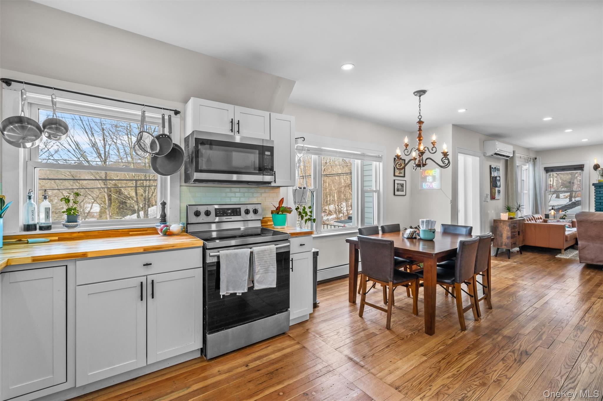 38 Post Hill Road Mountain Dale, NY 12763 - Photo 16 of 27 Kitchen with butcher block countertops, an AC wall unit, appliances with stainless steel finishes, white cabinets, and backsplash