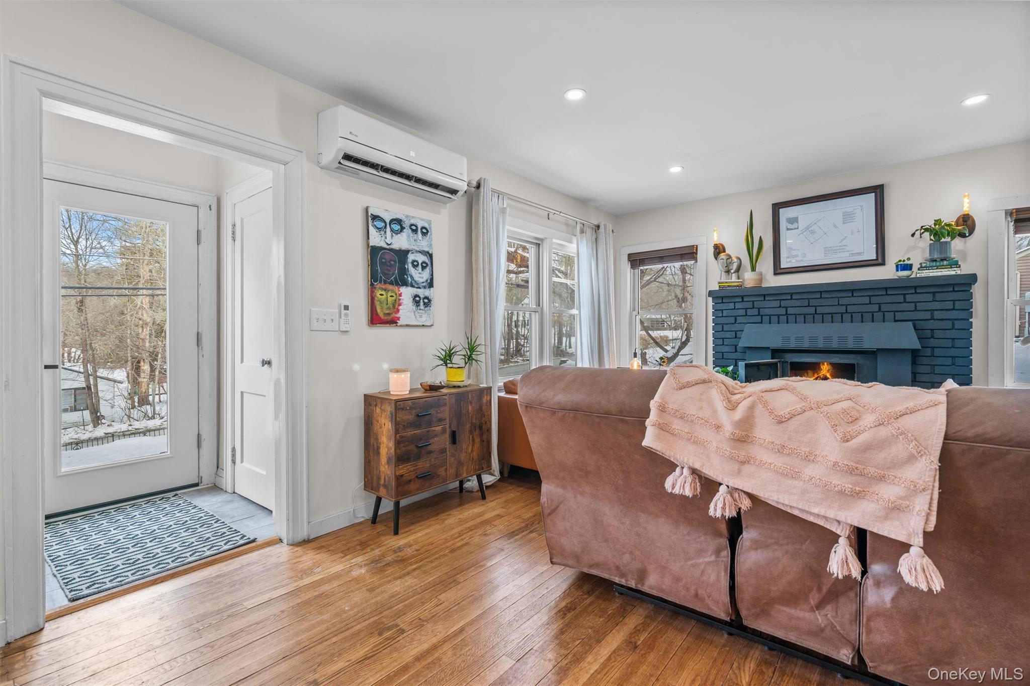 38 Post Hill Road Mountain Dale, NY 12763 - Photo 9 of 27 Living room with a fireplace, a wall unit AC, and light hardwood / wood-style floors